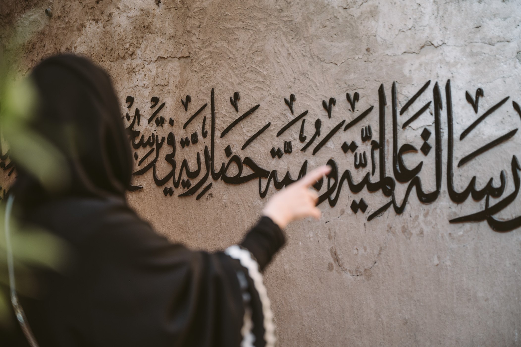 A poem on the wall of Al Fahidi gets translated during the Emirati Kashtas tour in Dubai