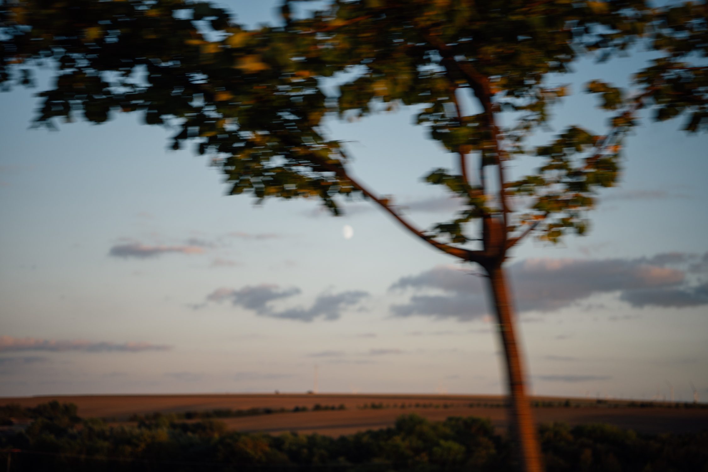 Moonrise as the autumn scenery is passing by in front of the car window in Thuringia Germany